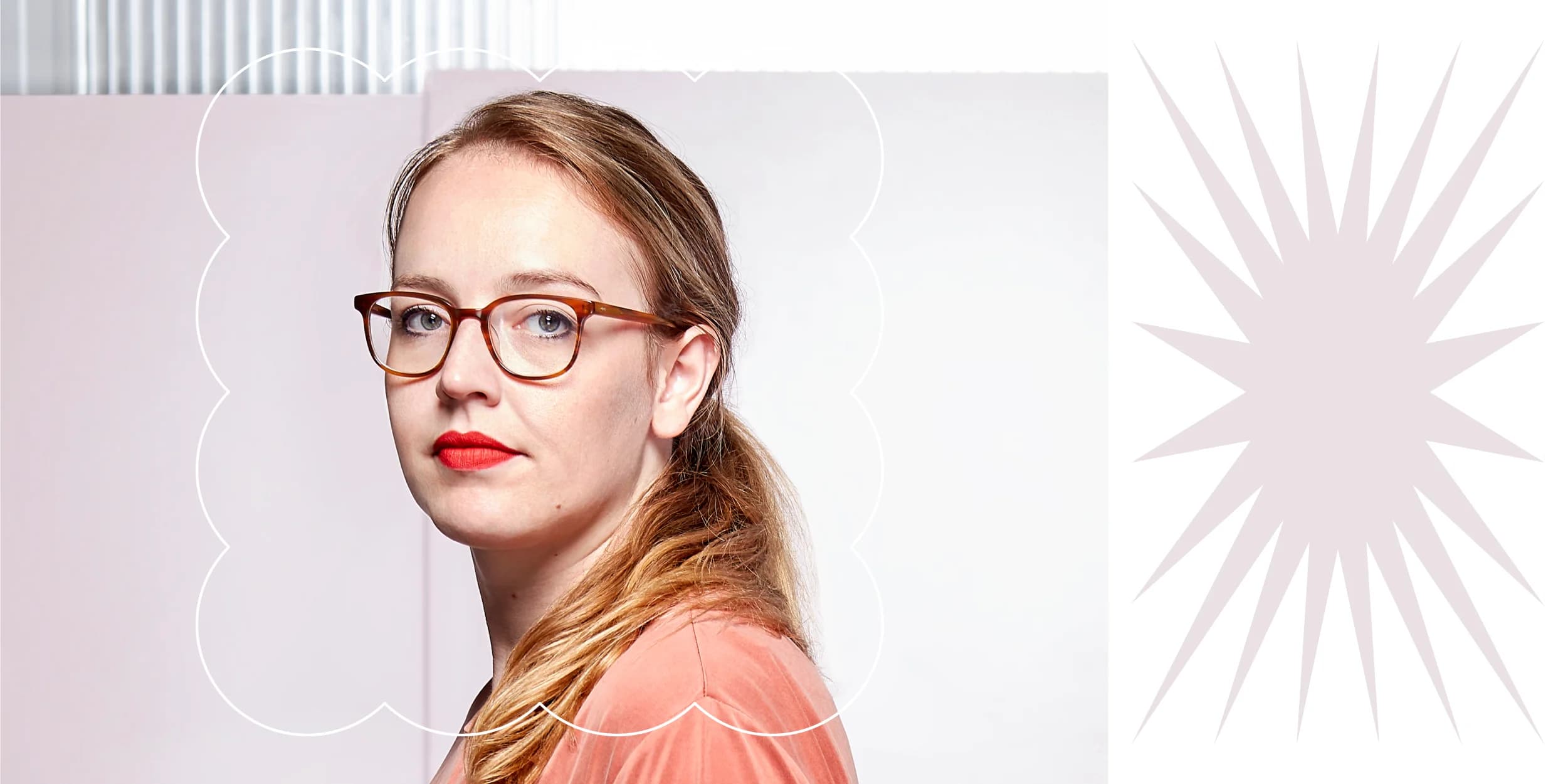 Woman with red lipstick, glasses, and a ponytail looks over her shoulder.