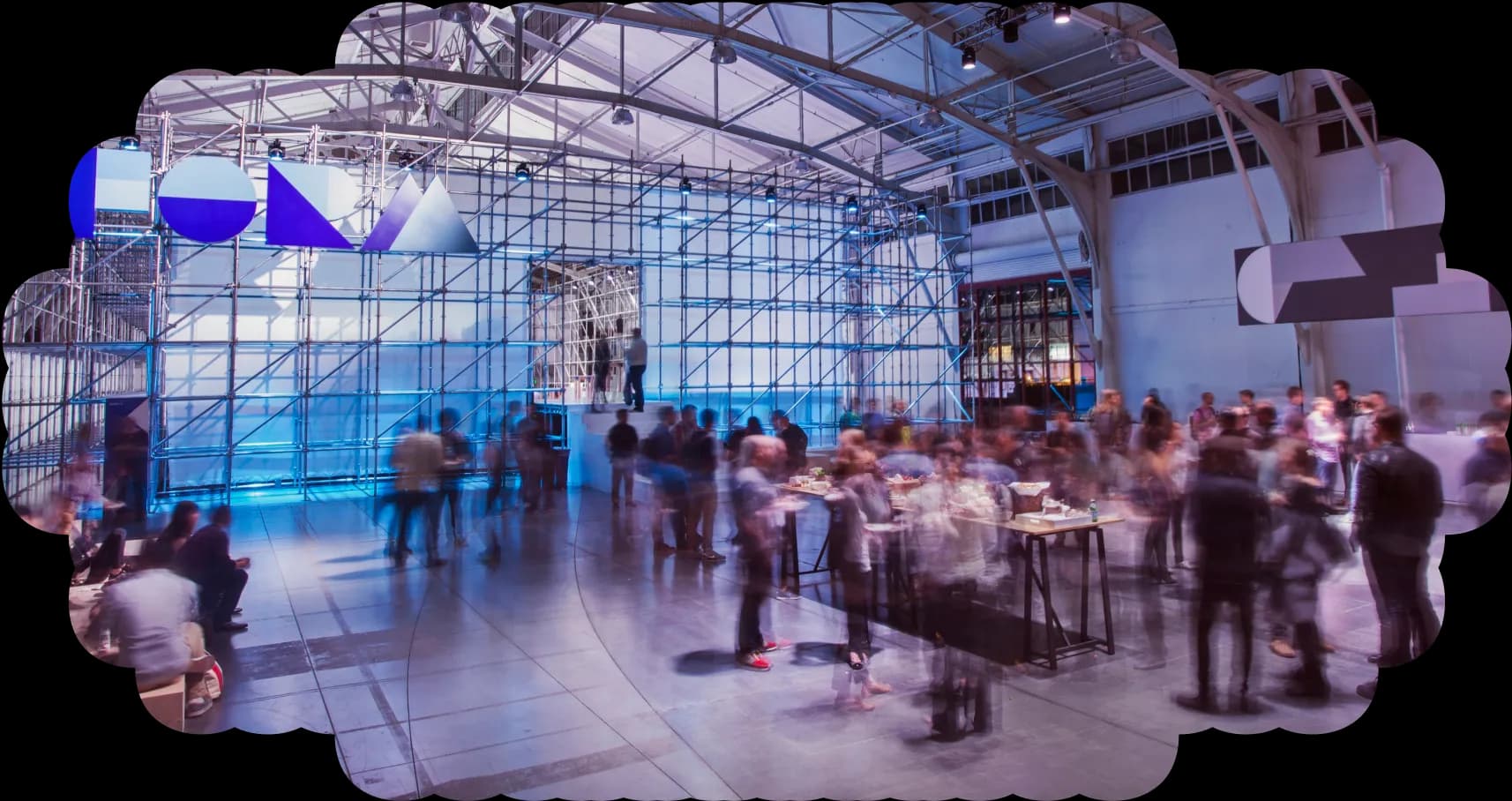 Blurred figures socialize at a vibrant, modern event space.