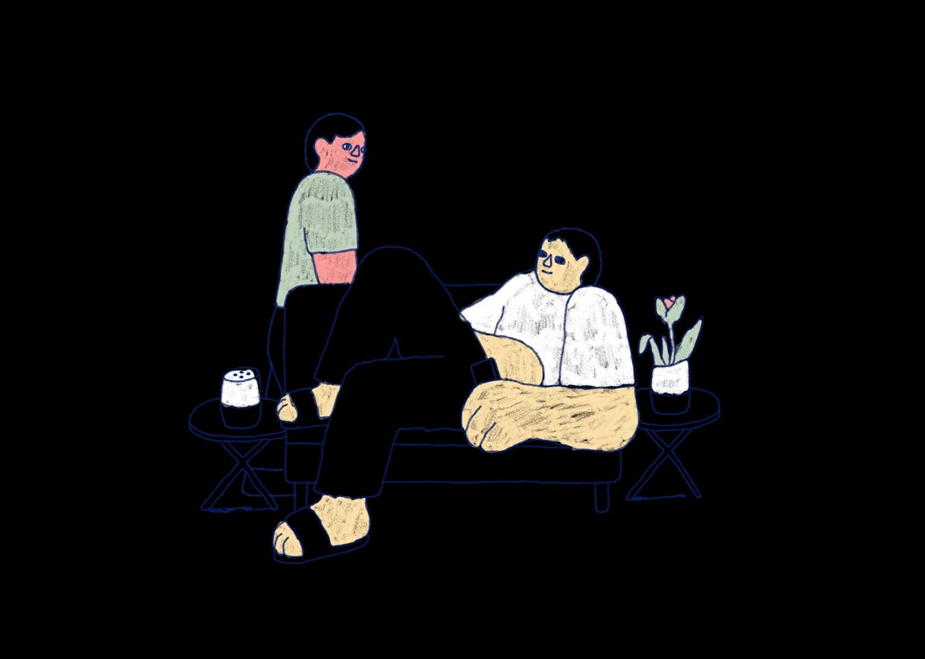 Two people in a living room. One lounges on the couch, while the other stands nearby.