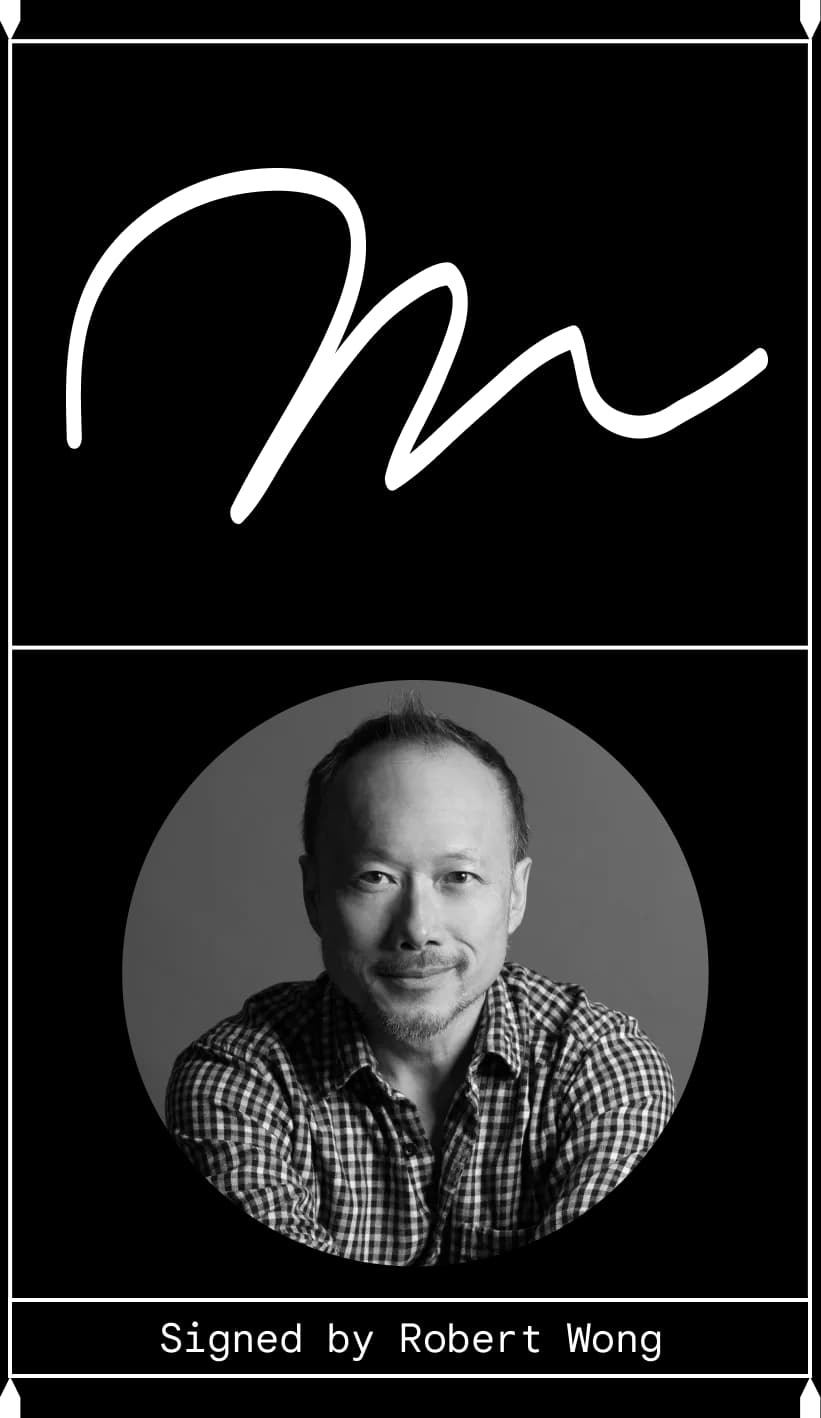 Curvy cursive "m" above a smiling man looking directly at the camera. Signed by Robert Wong.