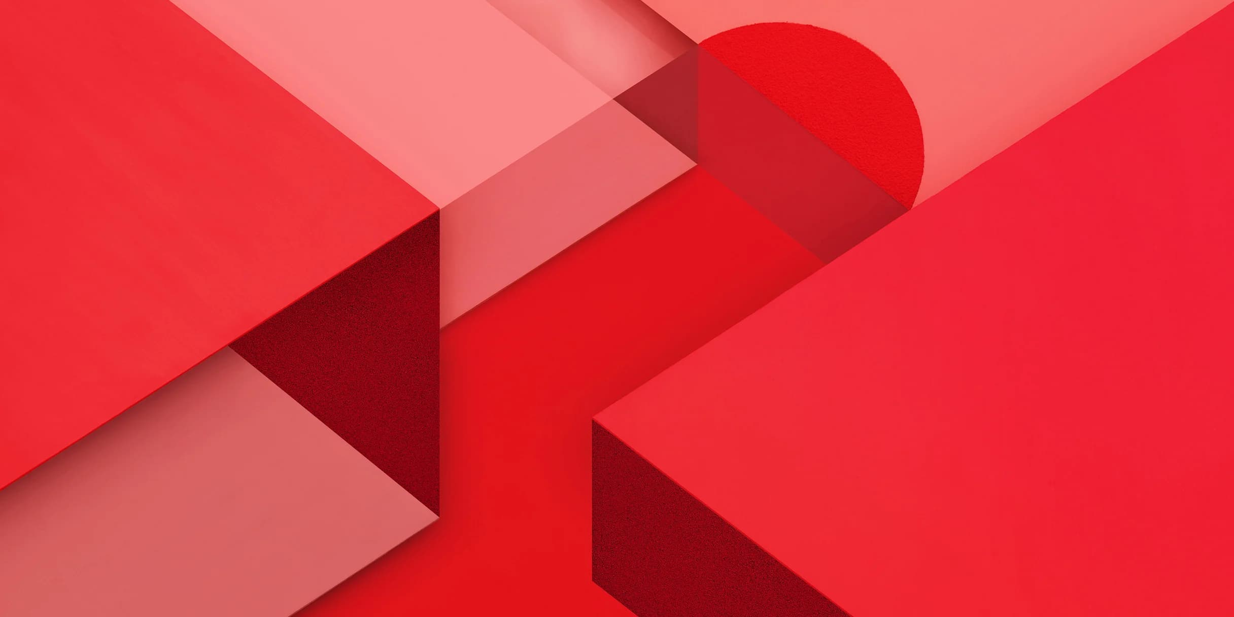 Abstract geometric design with overlapping red and pink shapes, including a textured circle and blocks.