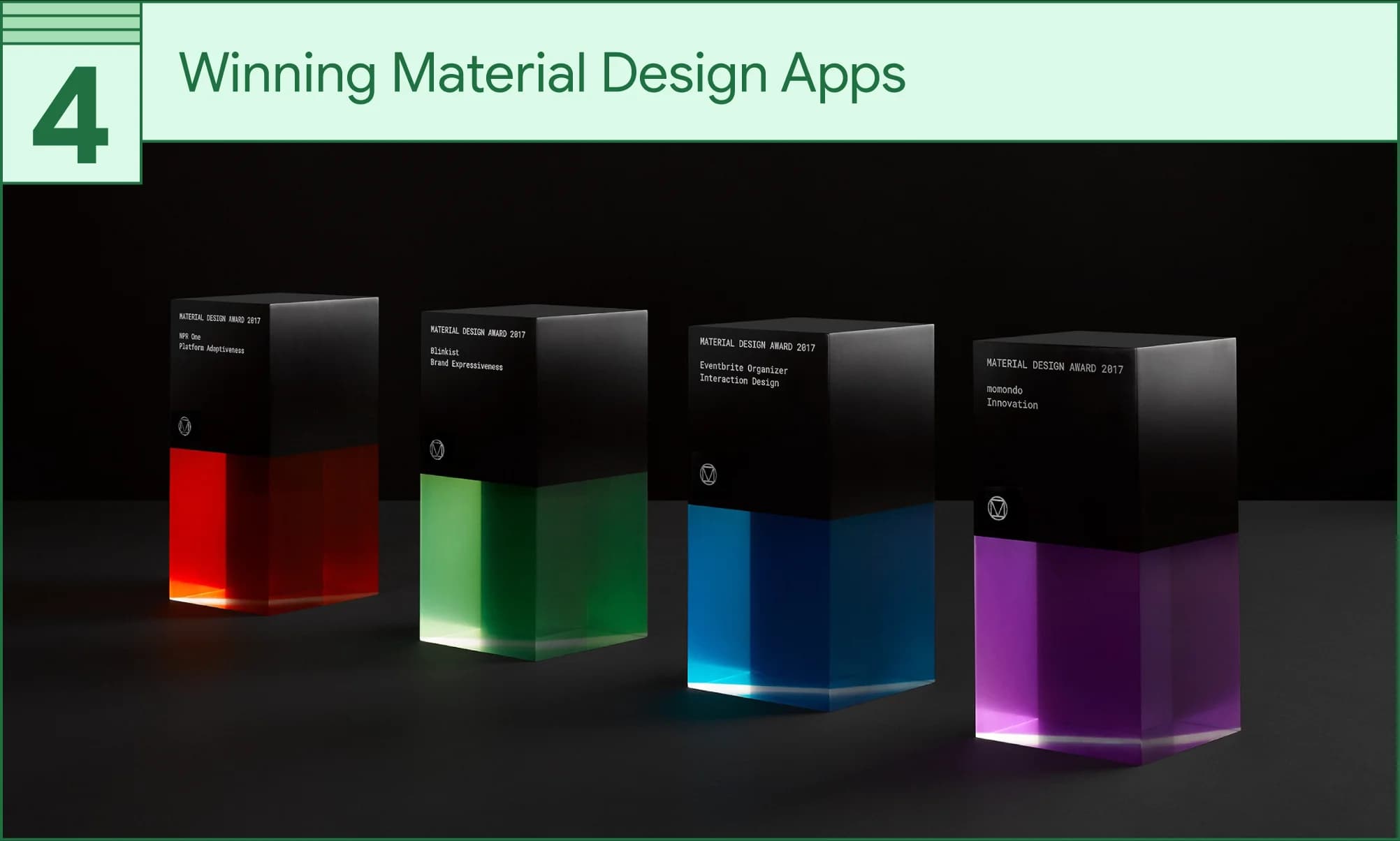 Four 2017 Material Design Award trophies glow red, green, blue, and purple against a dark background.