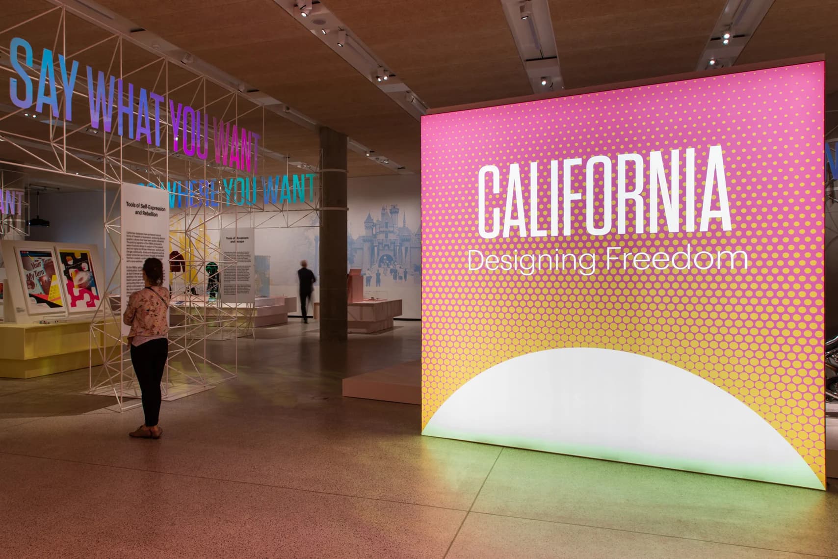 Museum visitors browse exhibits in the “California: Designing Freedom” exhibit showcasing California’s influence on counter-culture and social movements.