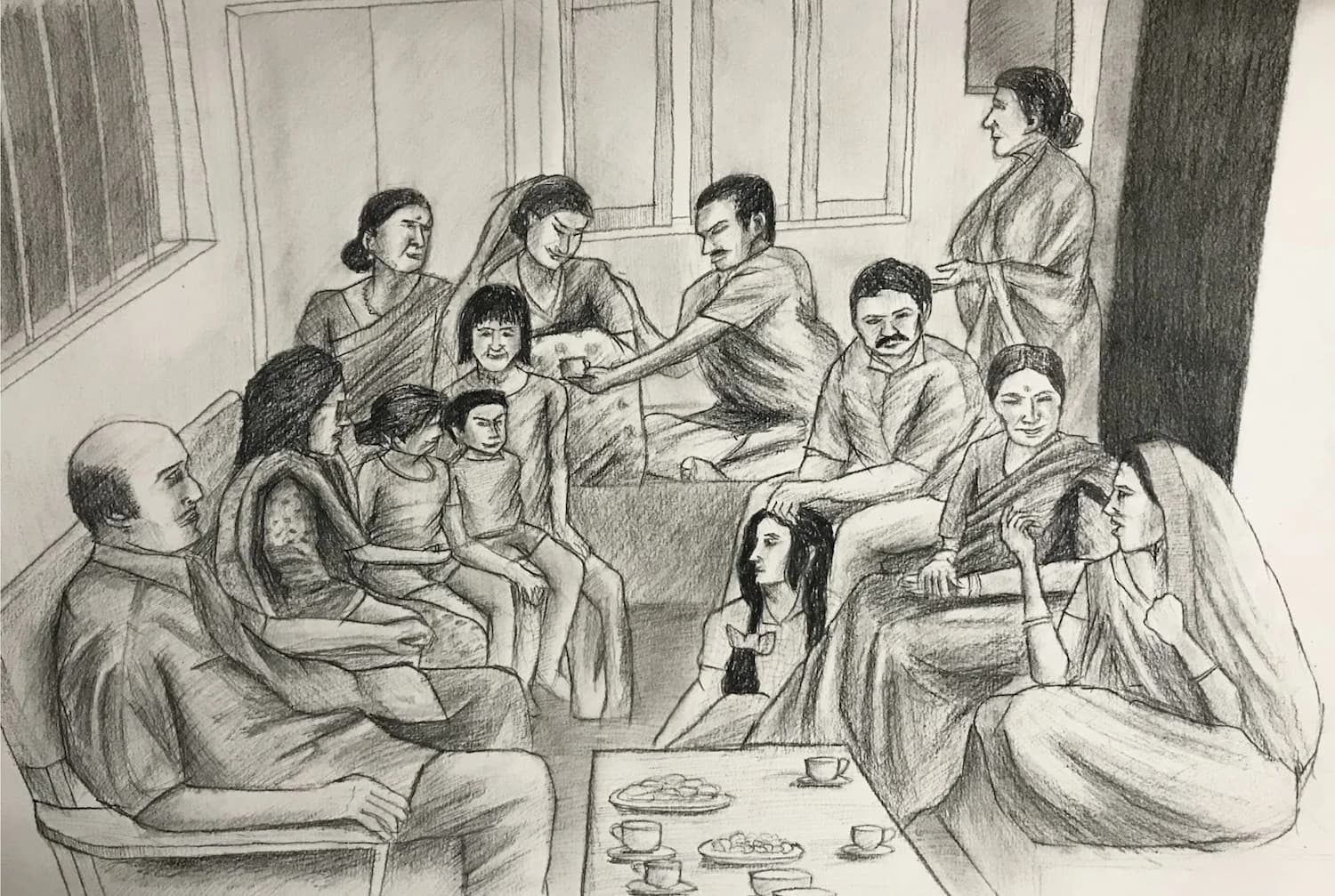 A multigenerational family gathers indoors. Women wear saris; men and children wear casual clothes. They sit, talk, and share refreshments.