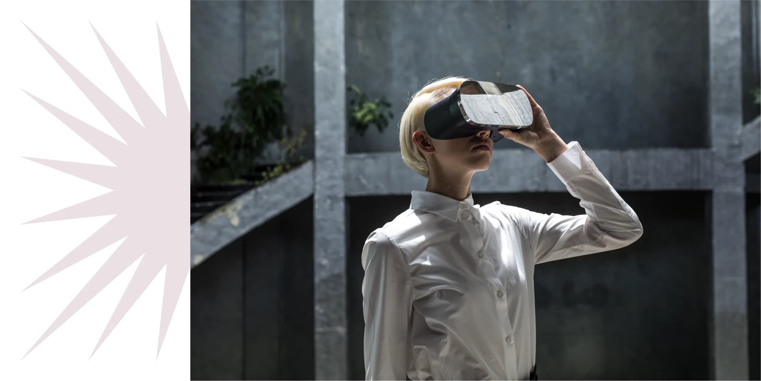 Woman with short blond hair wears a VR headset and a white button-down shirt in a modern, industrial space.