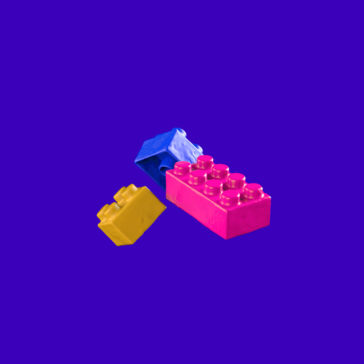 Three colorful toy building blocks, one blue, one pink, and one gold.